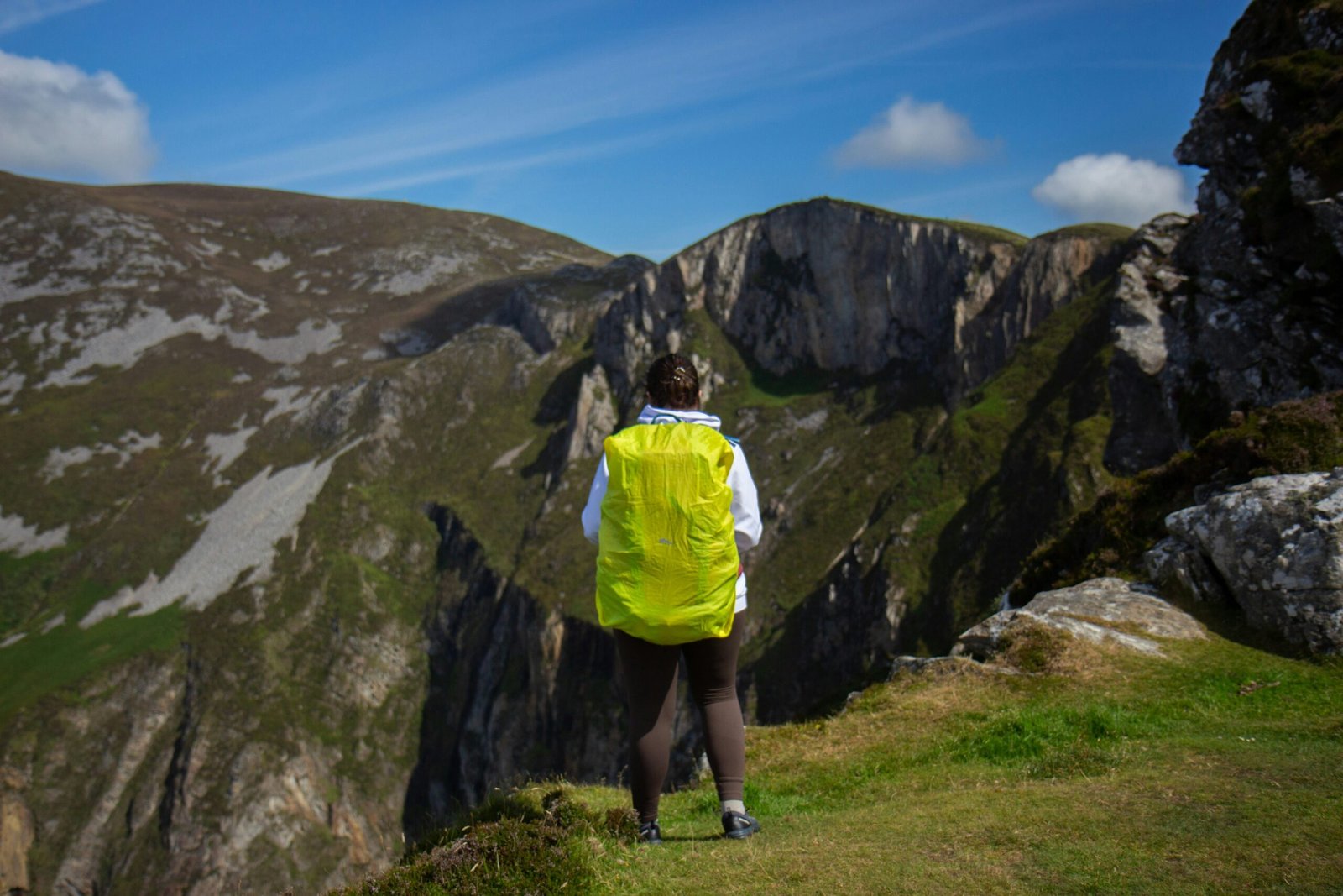 A person in a yellow jacket is standing on a hill